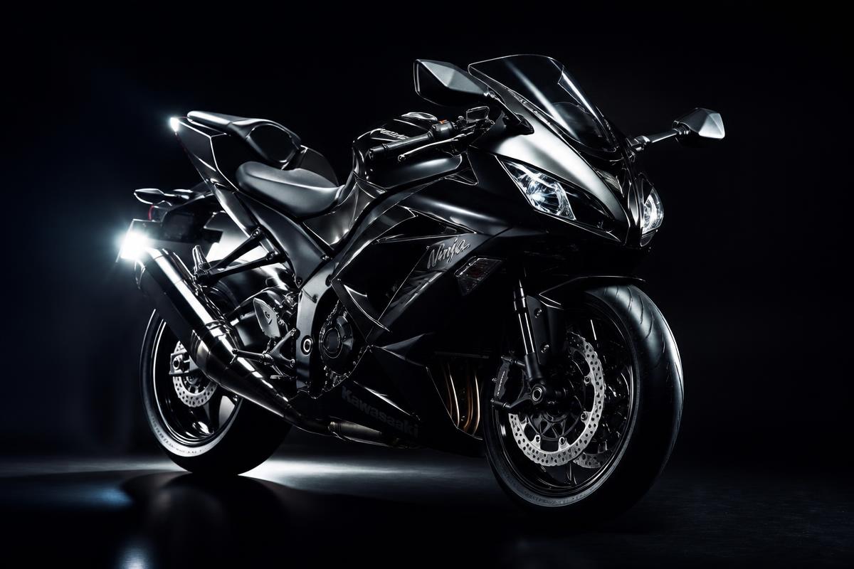 Glossy black sport motorcycle in a dark studio